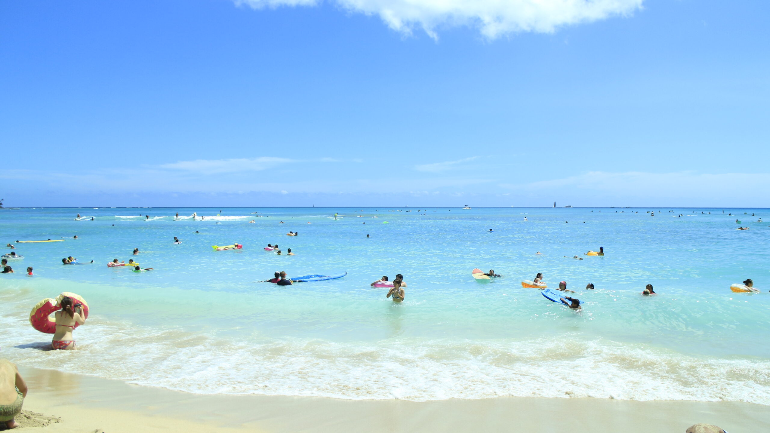 ワイキキビーチ 遠浅の海で泳ぐ人々