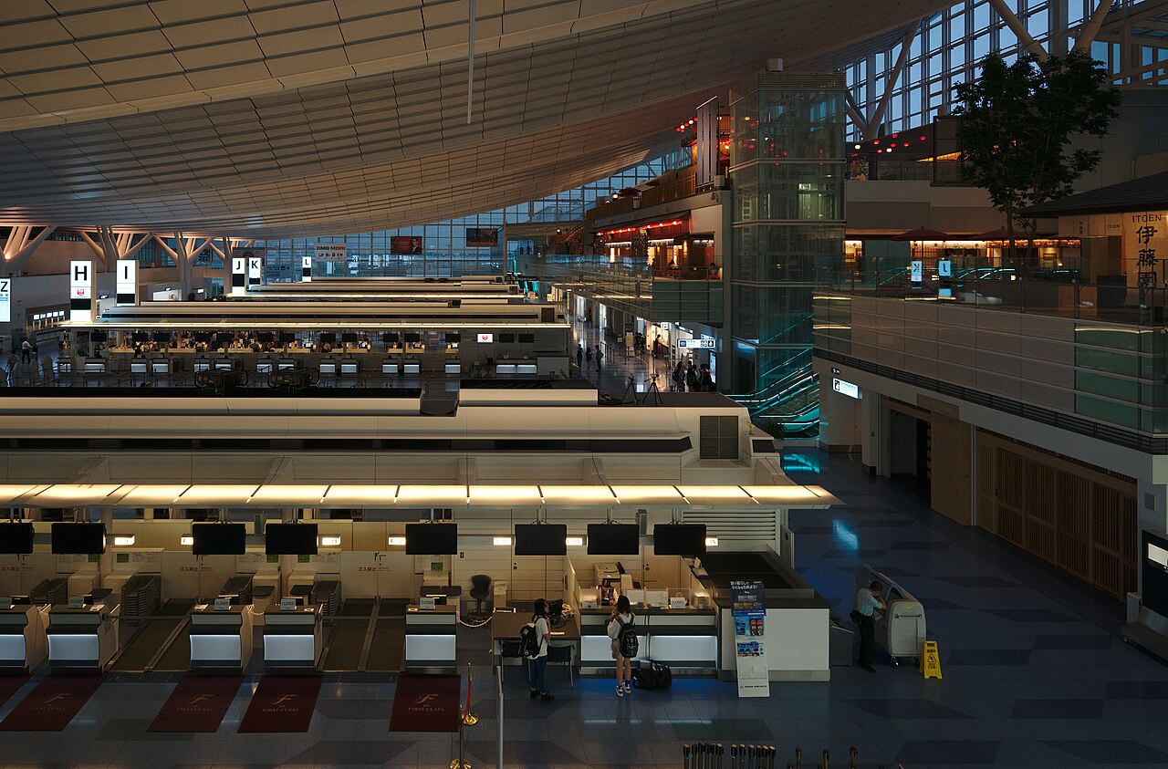 羽田空港のANA搭乗手続きカウンター付近。キャリーケースを持つ乗客が並ぶ